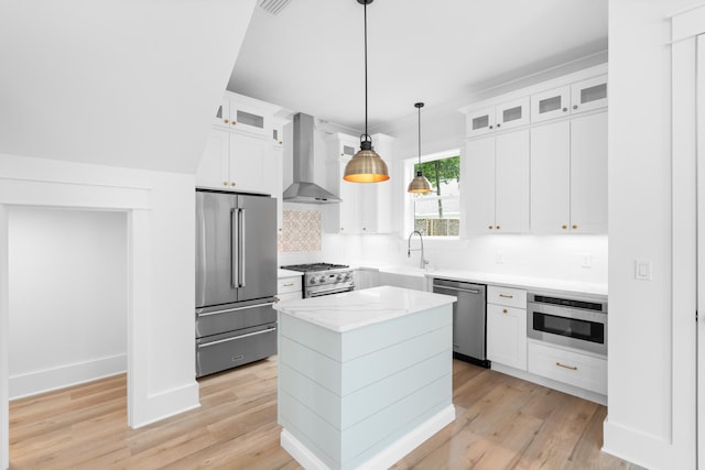 180 Rearden Way, Santa Rosa Beach, FL 32459 - kitchen with high end appliances, wall chimney range hood, decorative backsplash, a kitchen island, and light wood-style floors
