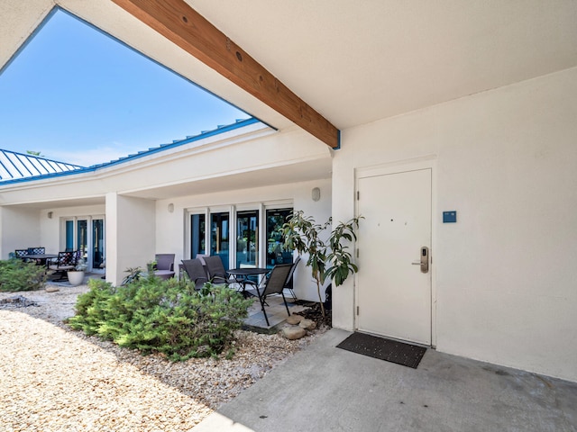 4205 Indian Bayou Trl Unit 10, Destin, FL 32541 - entrance to property with a patio, stucco siding, metal roof, and a standing seam roof