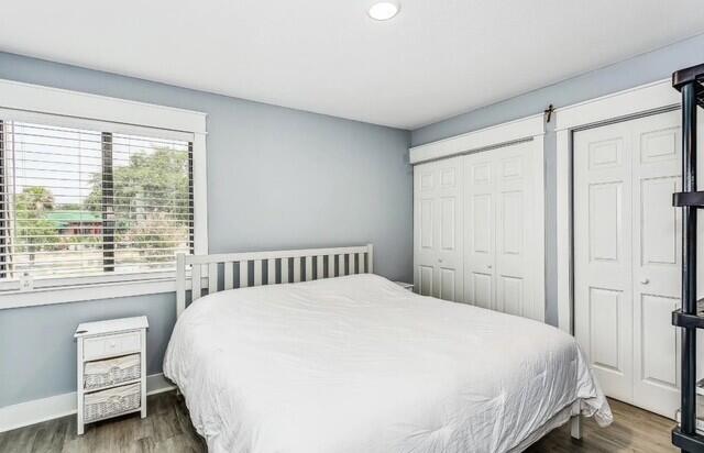 308 Miracle Strip Pkwy Unit 1C, Fort Walton Beach, FL 32548 - bedroom featuring wood finished floors, two closets, recessed lighting, and baseboards