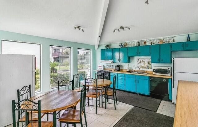 308 Miracle Strip Pkwy Unit 1C, Fort Walton Beach, FL 32548 - kitchen with stainless steel appliances, a sink, blue cabinets, rail lighting, and light countertops