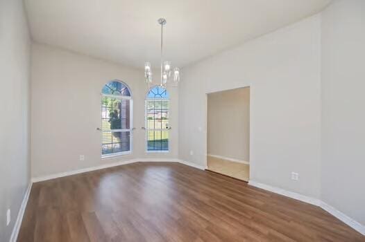 430 Hatchee Dr, Crestview, FL 32536 - empty room with wood finished floors, a chandelier, and baseboards