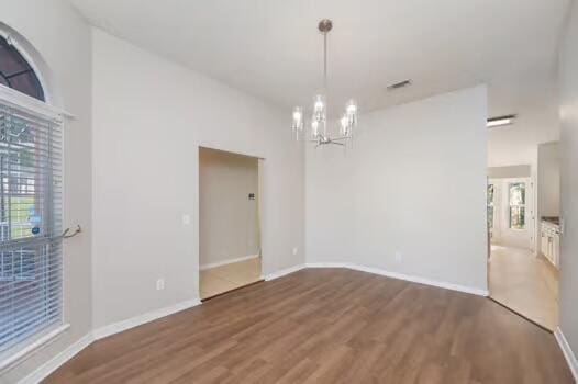 430 Hatchee Dr, Crestview, FL 32536 - unfurnished room with a chandelier, wood finished floors, baseboards, and a high ceiling