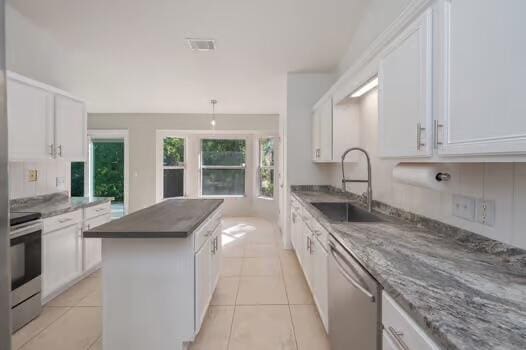 430 Hatchee Dr, Crestview, FL 32536 - kitchen featuring stainless steel appliances, a sink, a center island, and white cabinets
