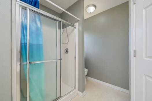 430 Hatchee Dr, Crestview, FL 32536 - bathroom featuring a shower stall, toilet, and baseboards