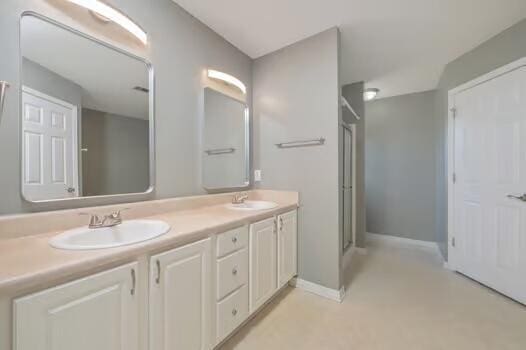 430 Hatchee Dr, Crestview, FL 32536 - bathroom with double vanity, an enclosed shower, and baseboards