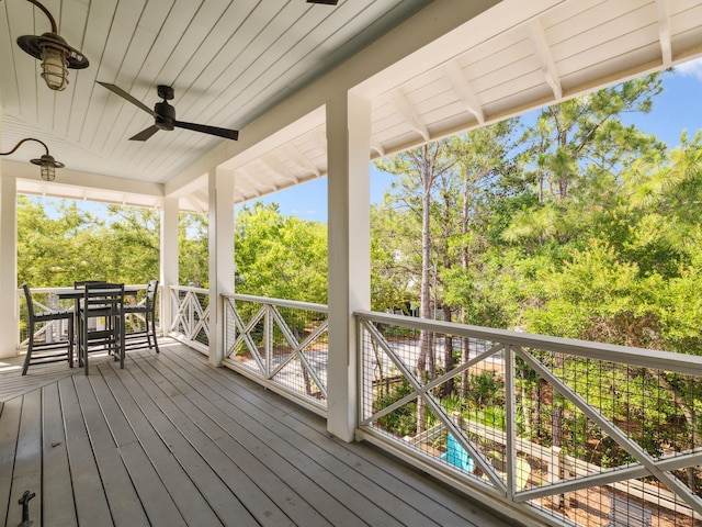 121 Red Cedar Way, Santa Rosa Beach, FL 32459 - wooden terrace featuring a ceiling fan, outdoor dining space, and view of wooded area