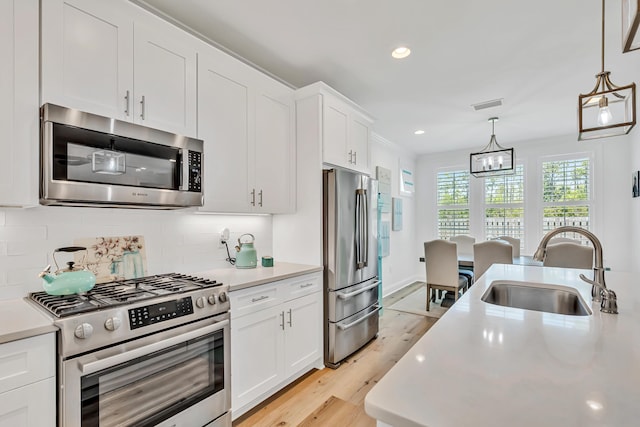101 Windrow Way Lot 255, Watersound, FL 32461 - kitchen with appliances with stainless steel finishes, a sink, light countertops, a chandelier, and decorative backsplash