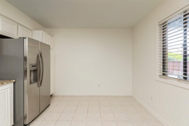 3871 Indian Trl Unit 2E, Destin, FL 32541 - kitchen featuring stainless steel refrigerator with ice dispenser, light stone counters, white cabinetry, and baseboards