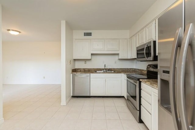 3871 Indian Trl Unit 2E, Destin, FL 32541 - kitchen with appliances with stainless steel finishes, a sink, white cabinetry, and light tile patterned floors