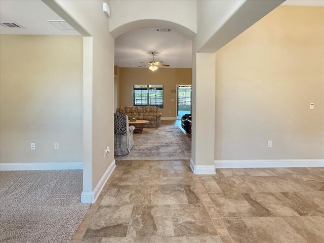 8296 Randall Dr, Navarre, FL 32566 - foyer entrance featuring ceiling fan, arched walkways, baseboards, and light stone finish floors