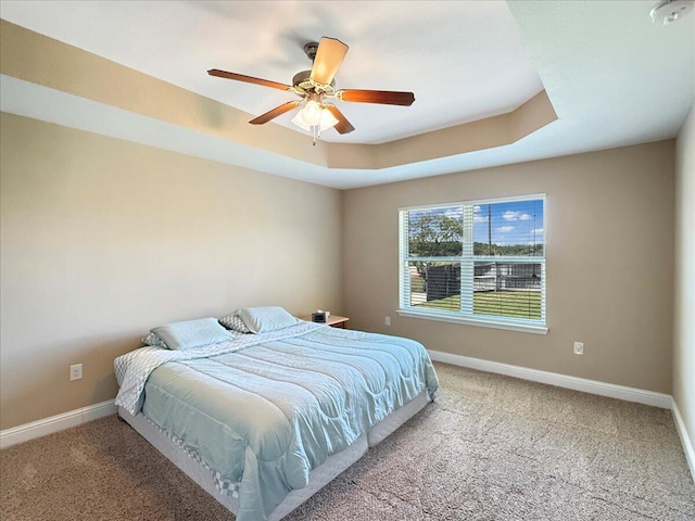 8296 Randall Dr, Navarre, FL 32566 - carpeted bedroom with baseboards, a raised ceiling, and a ceiling fan