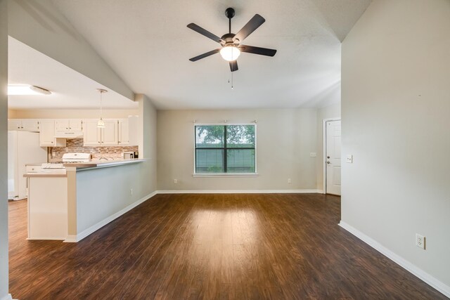 unfurnished living room with ceiling fan, dark wood finished floors, baseboards, and vaulted ceiling