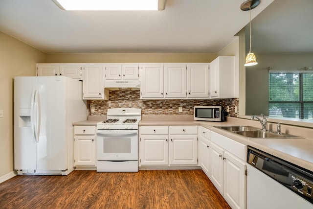 kitchen featuring white appliances, a sink, under cabinet range hood, dark wood-type flooring, and light countertops