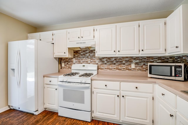 kitchen with white appliances, under cabinet range hood, light countertops, dark wood-style flooring, and white cabinetry