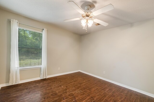 spare room with wood finished floors, a ceiling fan, and baseboards