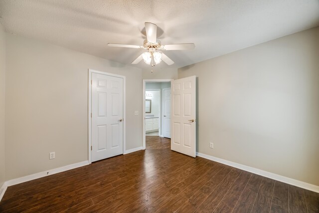 empty room featuring wood finished floors, a ceiling fan, and baseboards