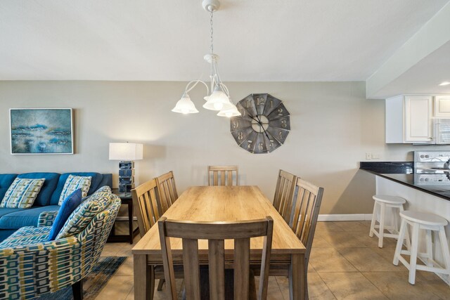 dining room featuring light tile patterned flooring, baseboards, and a chandelier