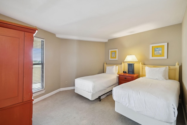bedroom with light carpet and baseboards