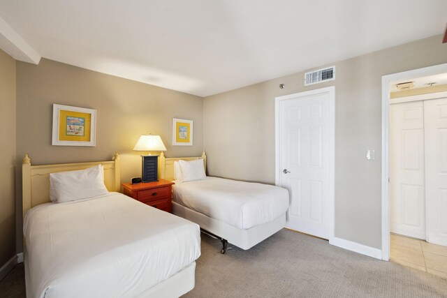 bedroom featuring light colored carpet and baseboards