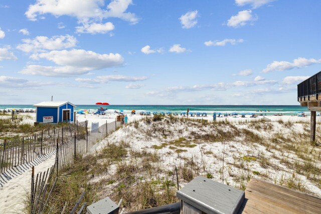 water view featuring nearby beach and fence