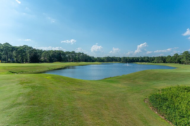 water view featuring a local golf course and a tree filled landscape