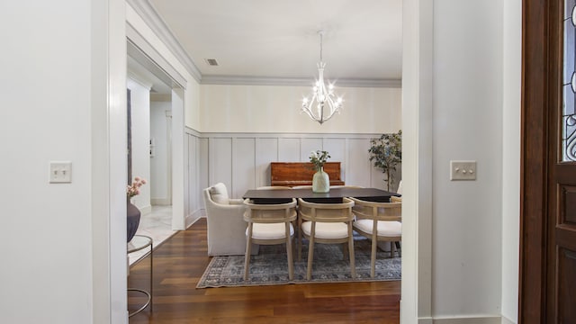 3208 Magnolia Islands Blvd, Panama City Beach, FL 32408 - dining area featuring a chandelier, wood finished floors, a wainscoted wall, a decorative wall, and ornamental molding