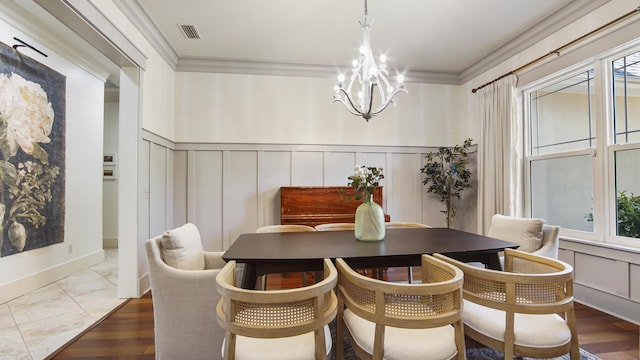 3208 Magnolia Islands Blvd, Panama City Beach, FL 32408 - dining room with a decorative wall, a chandelier, crown molding, a wainscoted wall, and wood finished floors