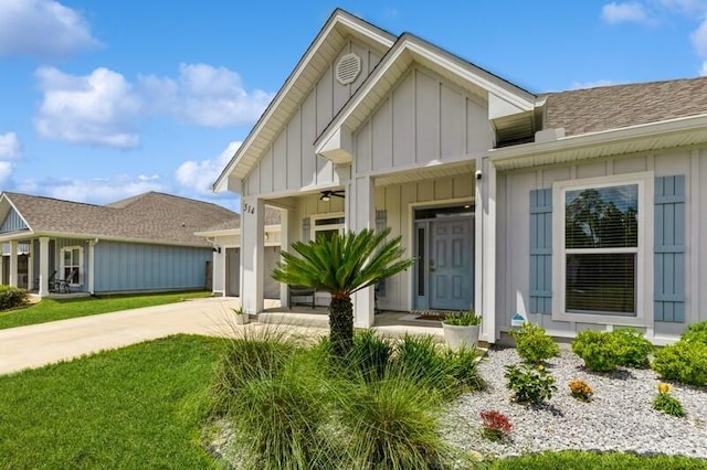 514 Mary Lou Way, Crestview, FL 32539 - view of front facade featuring board and batten siding, driveway, a garage, and a front lawn