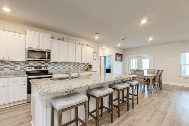 514 Mary Lou Way, Crestview, FL 32539 - kitchen featuring appliances with stainless steel finishes, a sink, tasteful backsplash, light wood-style flooring, and white cabinets