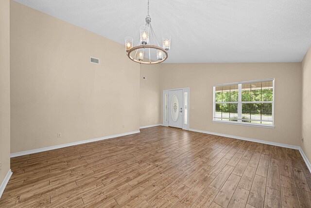749 Randall Roberts Rd, Fort Walton Beach, FL 32547 - empty room with a chandelier, wood finished floors, baseboards, and high vaulted ceiling