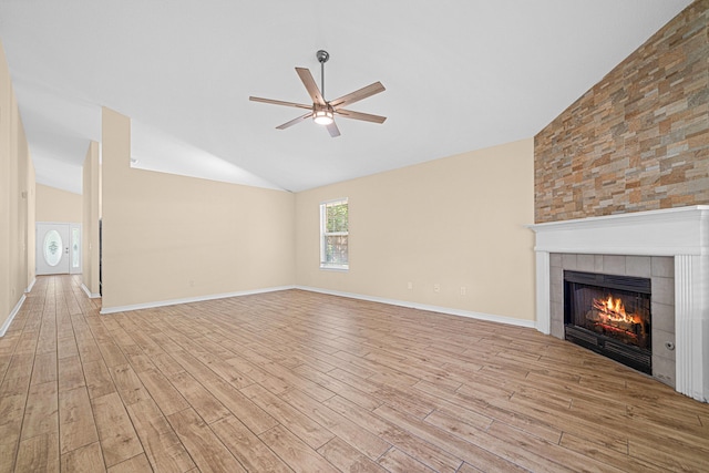 749 Randall Roberts Rd, Fort Walton Beach, FL 32547 - unfurnished living room featuring lofted ceiling, light wood-style floors, ceiling fan, a tiled fireplace, and baseboards