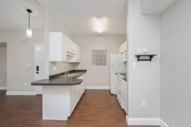 1501 N Partin Dr Unit 264, Niceville, FL 32578 - kitchen featuring dark countertops, a peninsula, dark wood-style floors, a sink, and white cabinets