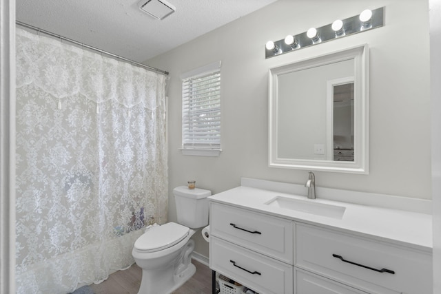 407 Apple Dr, Crestview, FL 32536 - bathroom featuring toilet, vanity, a textured ceiling, wood finished floors, and a shower with curtain