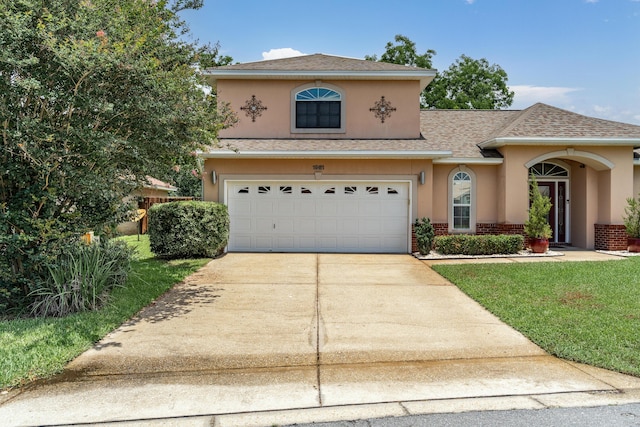 1961 Chesapeake Rdg, Fort Walton Beach, FL 32547 - view of front facade featuring concrete driveway, stucco siding, brick siding, roof with shingles, and an attached garage