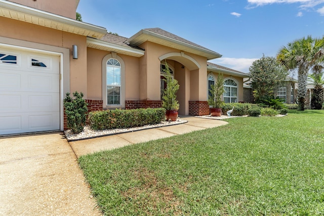 1961 Chesapeake Rdg, Fort Walton Beach, FL 32547 - view of front of home featuring brick siding, a front lawn, an attached garage, stucco siding, and a shingled roof