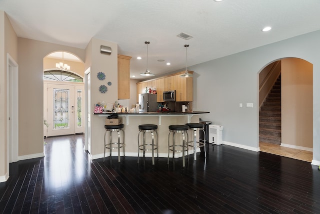 1961 Chesapeake Rdg, Fort Walton Beach, FL 32547 - kitchen with appliances with stainless steel finishes, light brown cabinetry, arched walkways, a kitchen bar, and hardwood / wood-style flooring