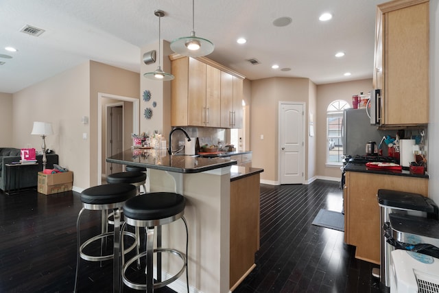 1961 Chesapeake Rdg, Fort Walton Beach, FL 32547 - kitchen with dark wood finished floors, dark countertops, a peninsula, a kitchen breakfast bar, and light brown cabinets
