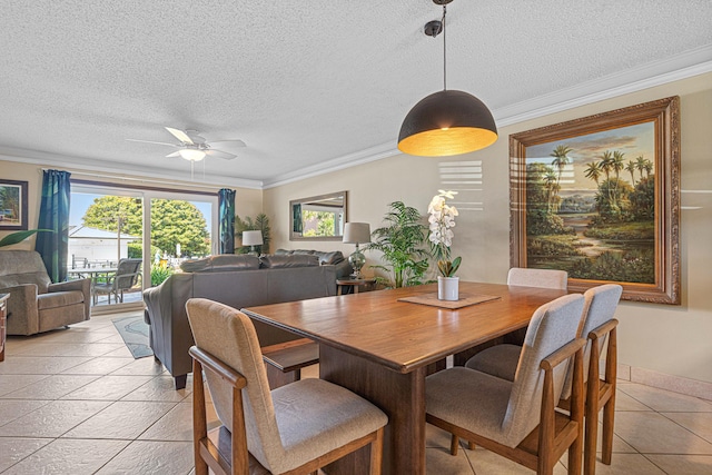 dining room featuring plenty of natural light, ceiling fan, a textured ceiling, ornamental molding, and baseboards