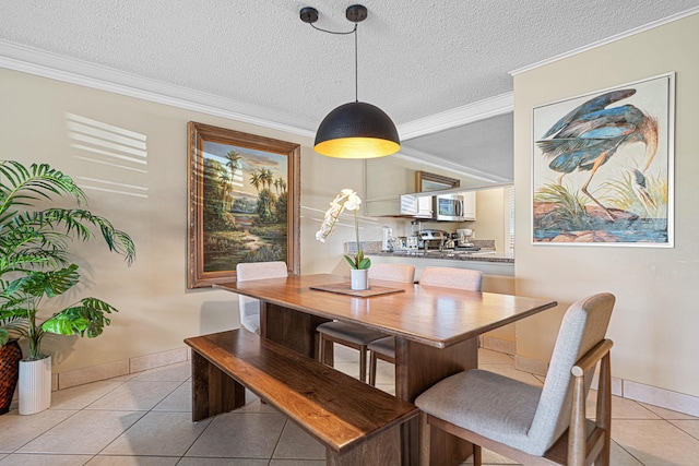 dining space featuring light tile patterned floors, ornamental molding, a textured ceiling, and baseboards