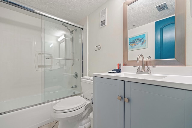 full bathroom with a textured ceiling, toilet, vanity, shower / bath combination with glass door, and tile patterned flooring