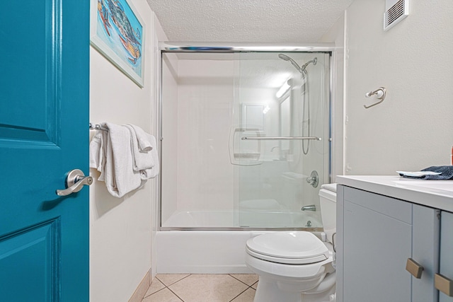 bathroom with toilet, a textured ceiling, tile patterned flooring, shower / bath combination with glass door, and vanity