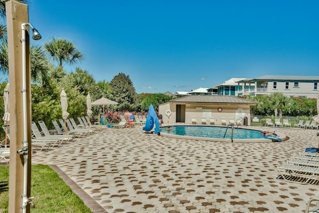 community pool with a patio area and fence