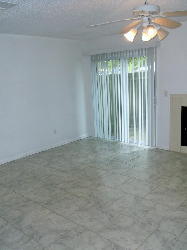 302 Olympia Ct, Fort Walton Beach, FL 32547 - empty room with marble look tiles, ceiling fan, and a textured ceiling