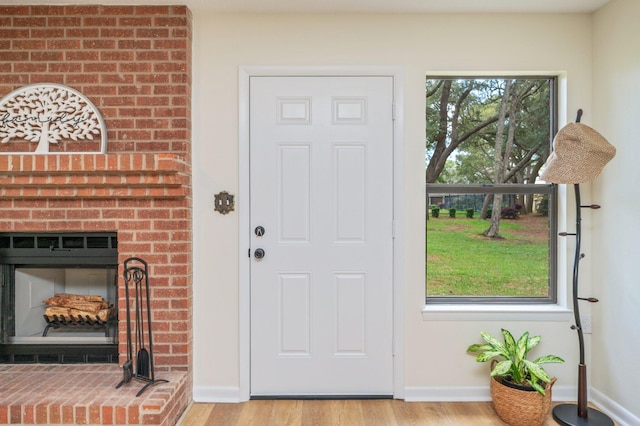 128 5th Ave, Shalimar, FL 32579 - foyer entrance with wood finished floors, a brick fireplace, and baseboards