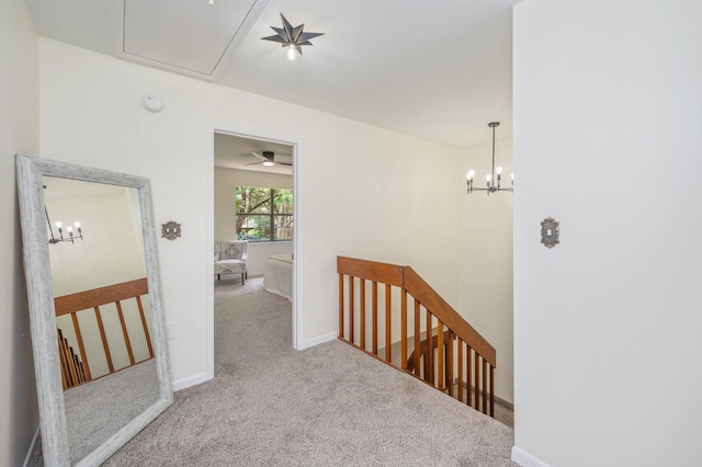128 5th Ave, Shalimar, FL 32579 - hallway featuring an upstairs landing, attic access, carpet floors, a chandelier, and baseboards