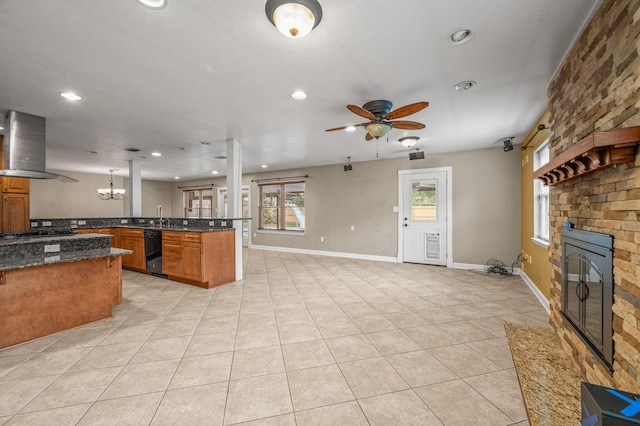 3 NE Windsor Ln, Fort Walton Beach, FL 32547 - kitchen with wall chimney exhaust hood, dishwasher, brown cabinetry, open floor plan, and a fireplace