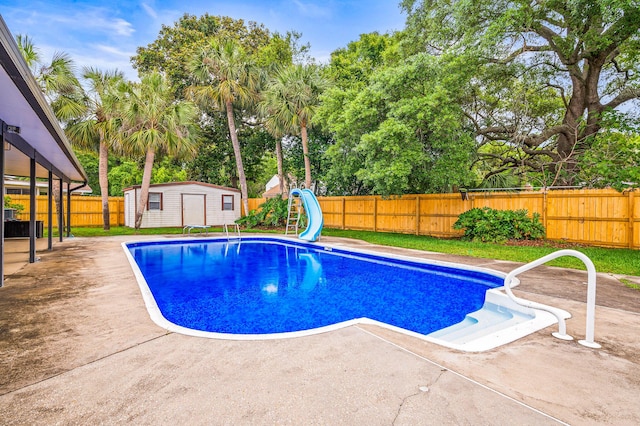 3 NE Windsor Ln, Fort Walton Beach, FL 32547 - view of swimming pool with a water slide, a patio area, a fenced backyard, and view of wooded area