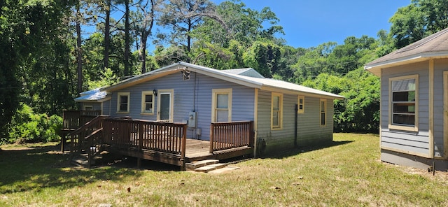 back of property with a yard and a wooden deck