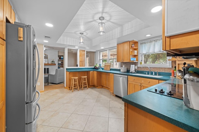 197 Country Club Rd, Shalimar, FL 32579 - kitchen featuring appliances with stainless steel finishes, a tray ceiling, a sink, a peninsula, and light tile patterned floors
