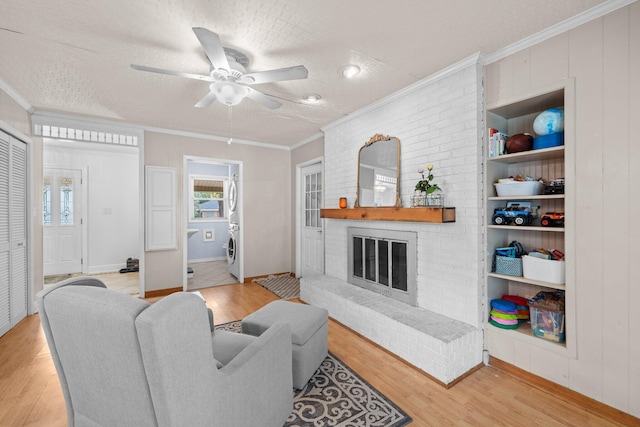 197 Country Club Rd, Shalimar, FL 32579 - living room with light wood-type flooring, washer / dryer, crown molding, ceiling fan, and a brick fireplace